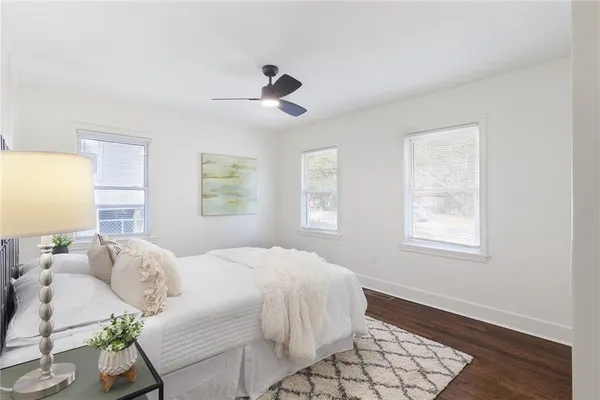 a bedroom with a bed wooden floor and window