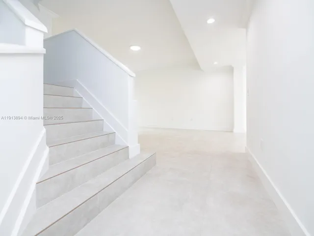 a kitchen with stainless steel appliances granite countertop a refrigerator a sink a stove and white cabinets