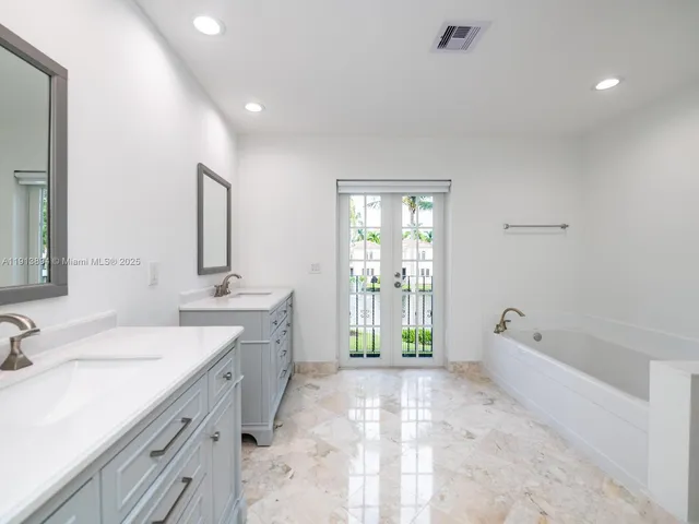 a bathroom with a toilet a sink a mirror a bathtub and vanity