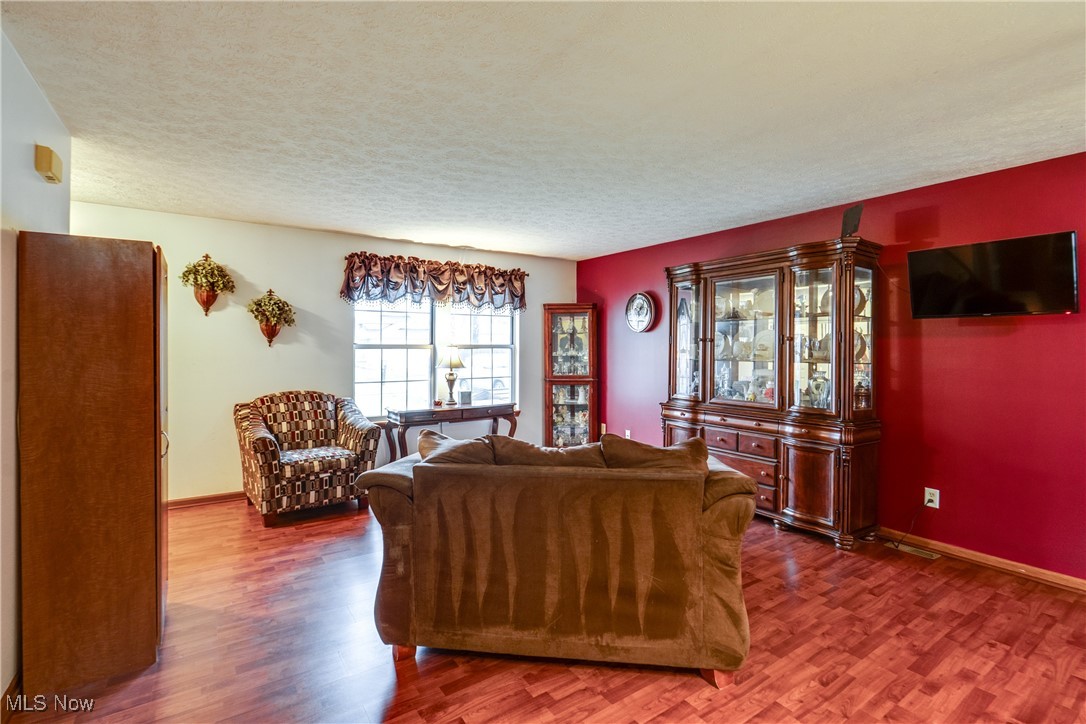 5844 Ridgeview Boulevard North Ridgeville, OH 44039 - Photo 9 of 28 Living room featuring wood finished floors, a textured ceiling, and baseboards