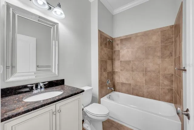 a bathroom with a granite countertop sink a toilet and bathtub