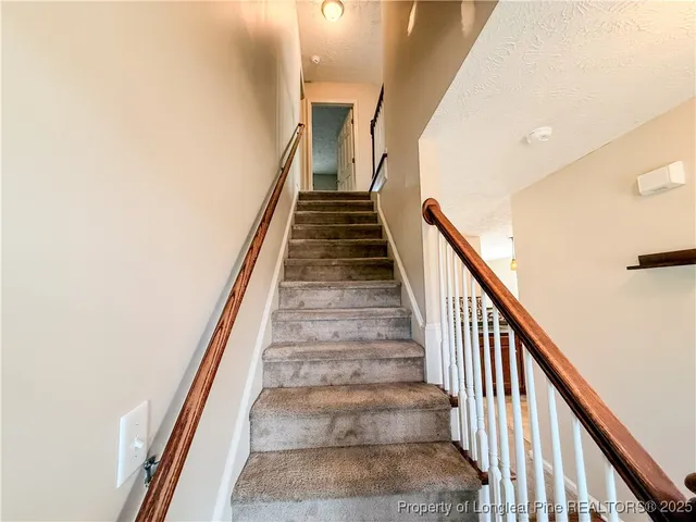 an empty room with windows and ceiling fan