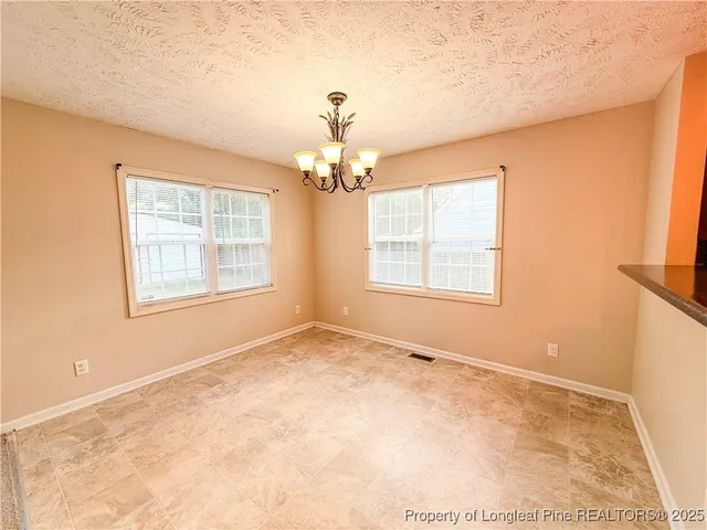 an empty room with windows and fireplace