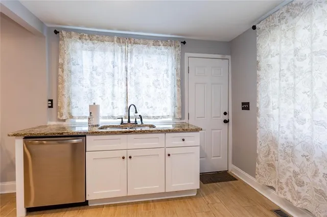 a kitchen with white cabinets and sink