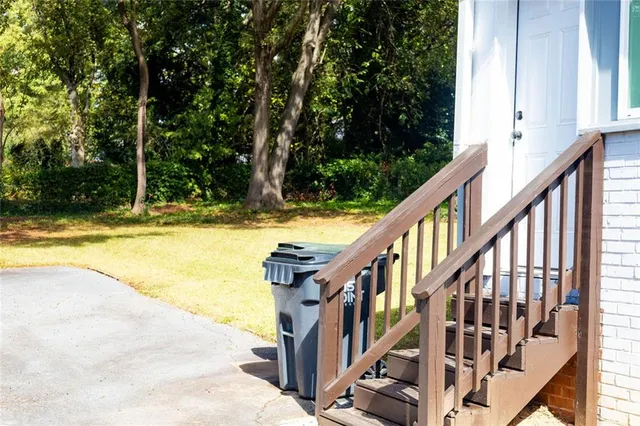 a view of swimming pool with lawn chairs and plants