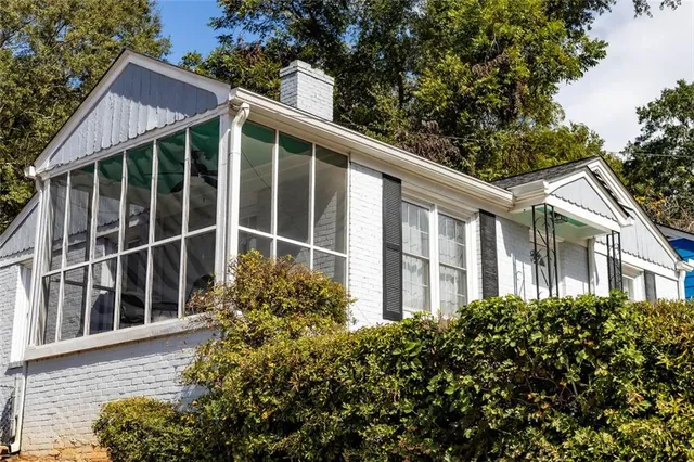 a view of a house with a large window and flower plants