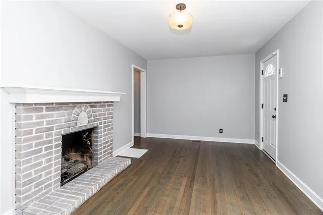an empty room with wooden floor and fireplace