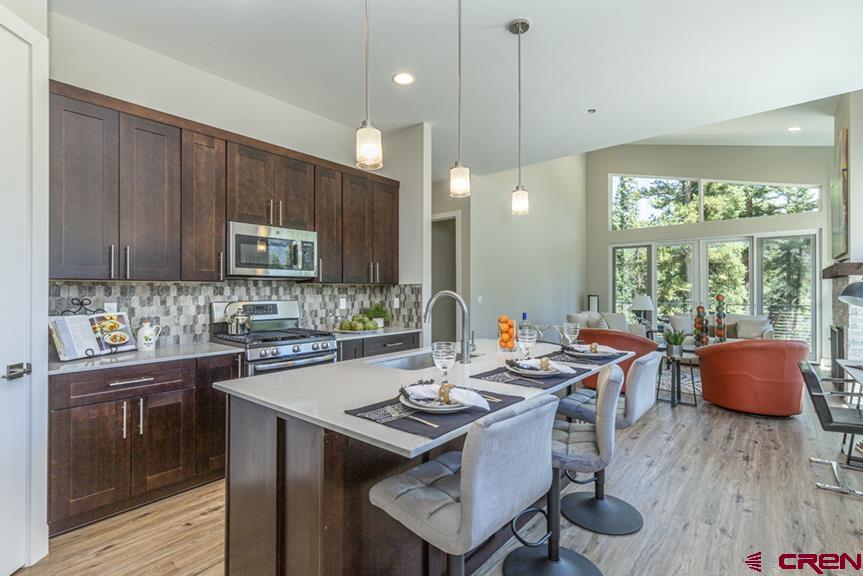 115 Travertine Trail, Unit PHASE III 4 Durango, CO 81301 - Photo 14 of 34 a kitchen with a sink and wooden cabinets