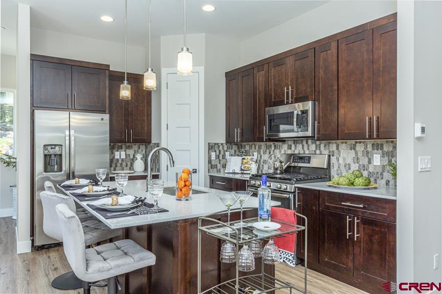 115 Travertine Trail, Unit PHASE III 4 Durango, CO 81301 - Photo 15 of 34 a kitchen with a sink a microwave and cabinets