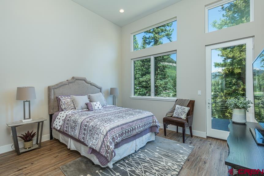115 Travertine Trail, Unit PHASE III 4 Durango, CO 81301 - Photo 18 of 34 a bedroom with a bed a lamp and a large window