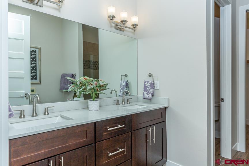 115 Travertine Trail, Unit PHASE III 4 Durango, CO 81301 - Photo 19 of 34 a bathroom with a granite countertop sink and a mirror