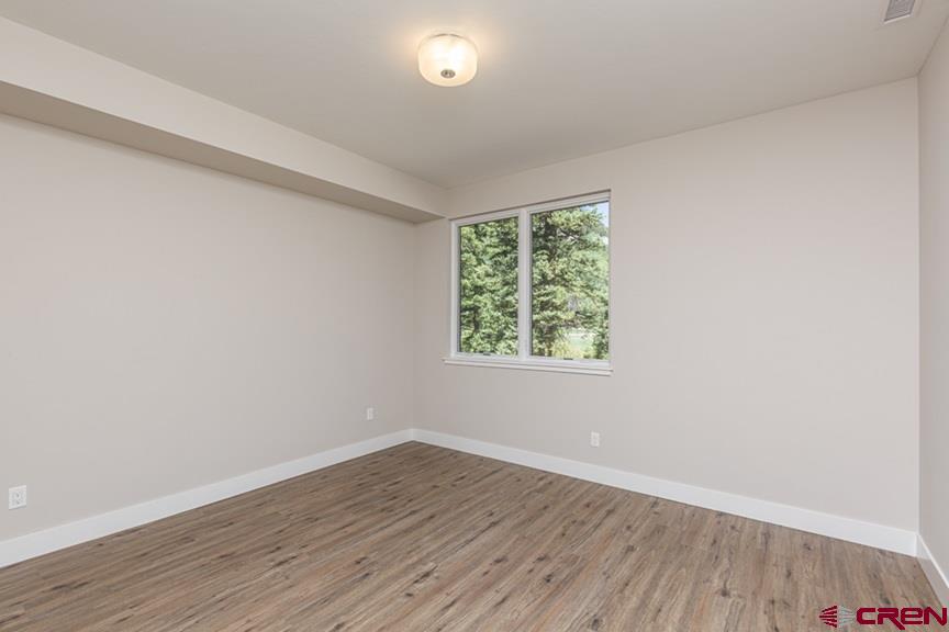 115 Travertine Trail, Unit PHASE III 4 Durango, CO 81301 - Photo 23 of 34 an empty room with wooden floor and windows