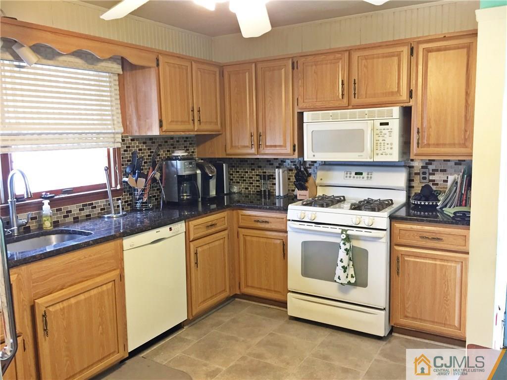 9 Sine Road Edison, NJ 08817 - Photo 3 of 21 a kitchen with granite countertop white cabinets sink and stainless steel appliances