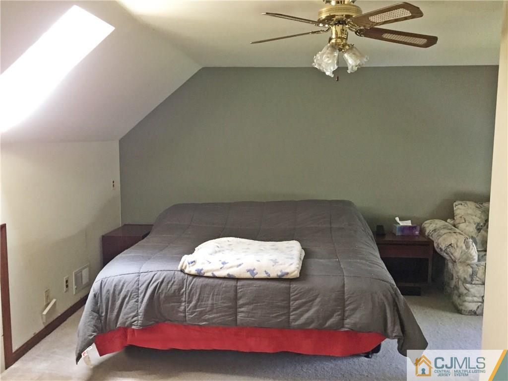 9 Sine Road Edison, NJ 08817 - Photo 7 of 21 a bedroom with a bed and a chandelier