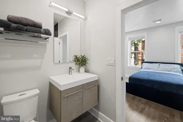 a bathroom with a toilet sink and mirror