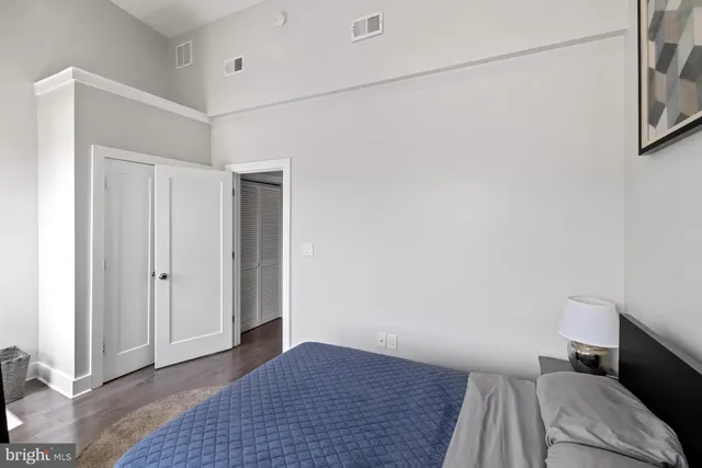 a living room with stainless steel appliances kitchen island granite countertop a couch and wooden floor
