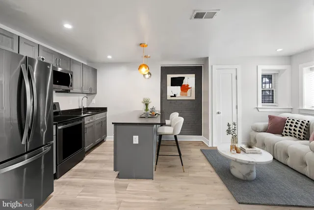 a kitchen with stainless steel appliances granite countertop a refrigerator stove top oven and sink