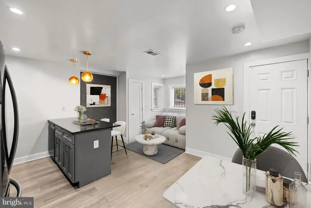 a kitchen with granite countertop a refrigerator a stove a microwave and island with wooden floor