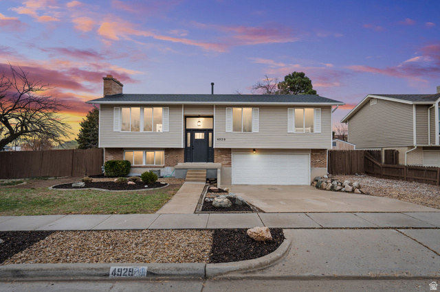 4929 Huntington Road Taylorsville, UT 84129 - Photo 1 of 1 Raised ranch featuring brick siding, driveway, a chimney, and a garage