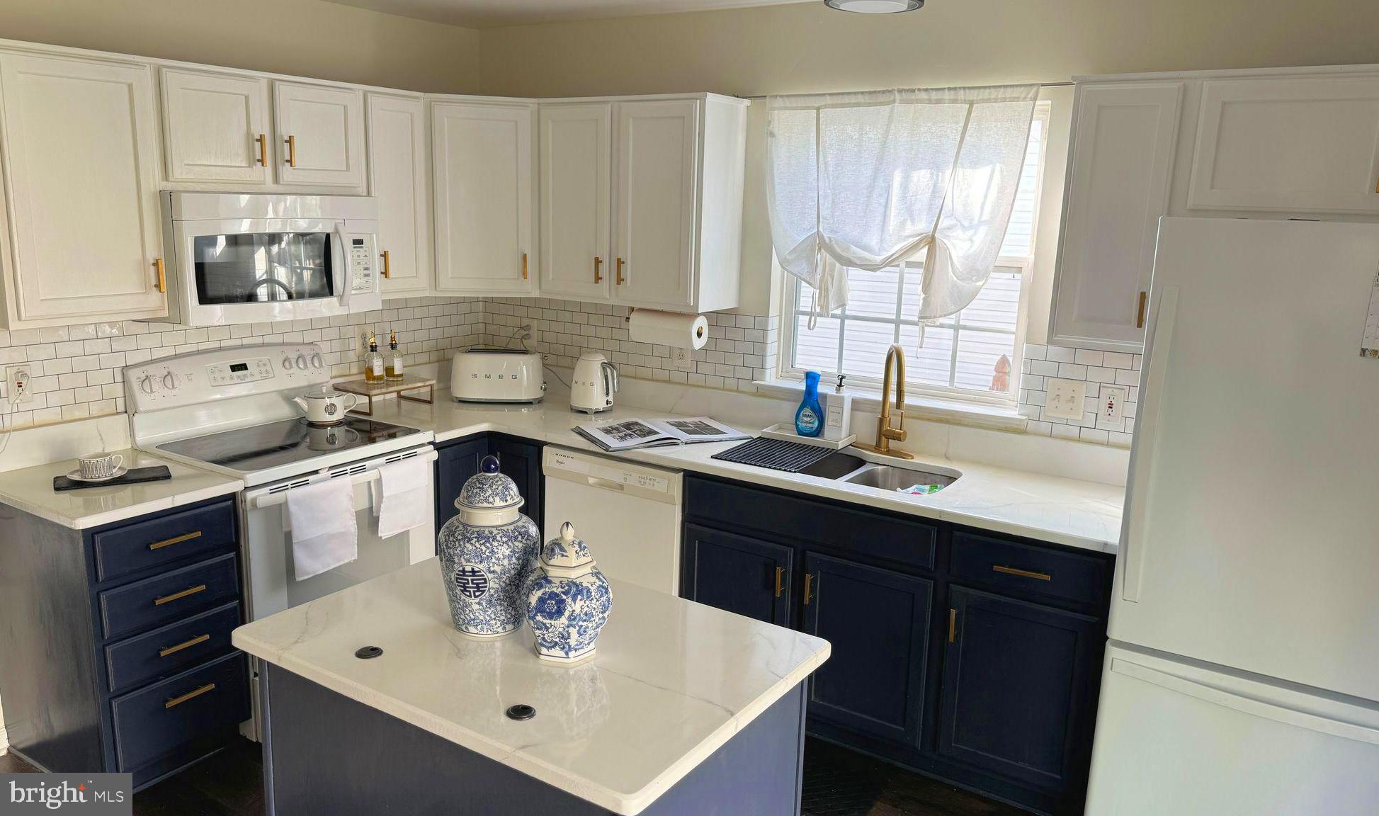 14660 Red House Road Gainesville, VA 20155 - Photo 11 of 20 a kitchen with a sink a stove and white cabinets
