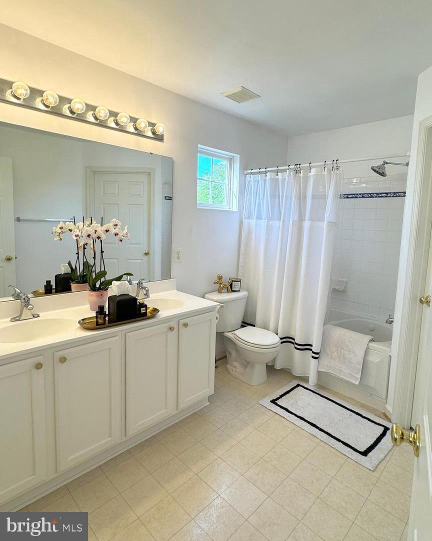 14660 Red House Road Gainesville, VA 20155 - Photo 13 of 20 a bathroom with a double vanity sink a mirror and a bathtub