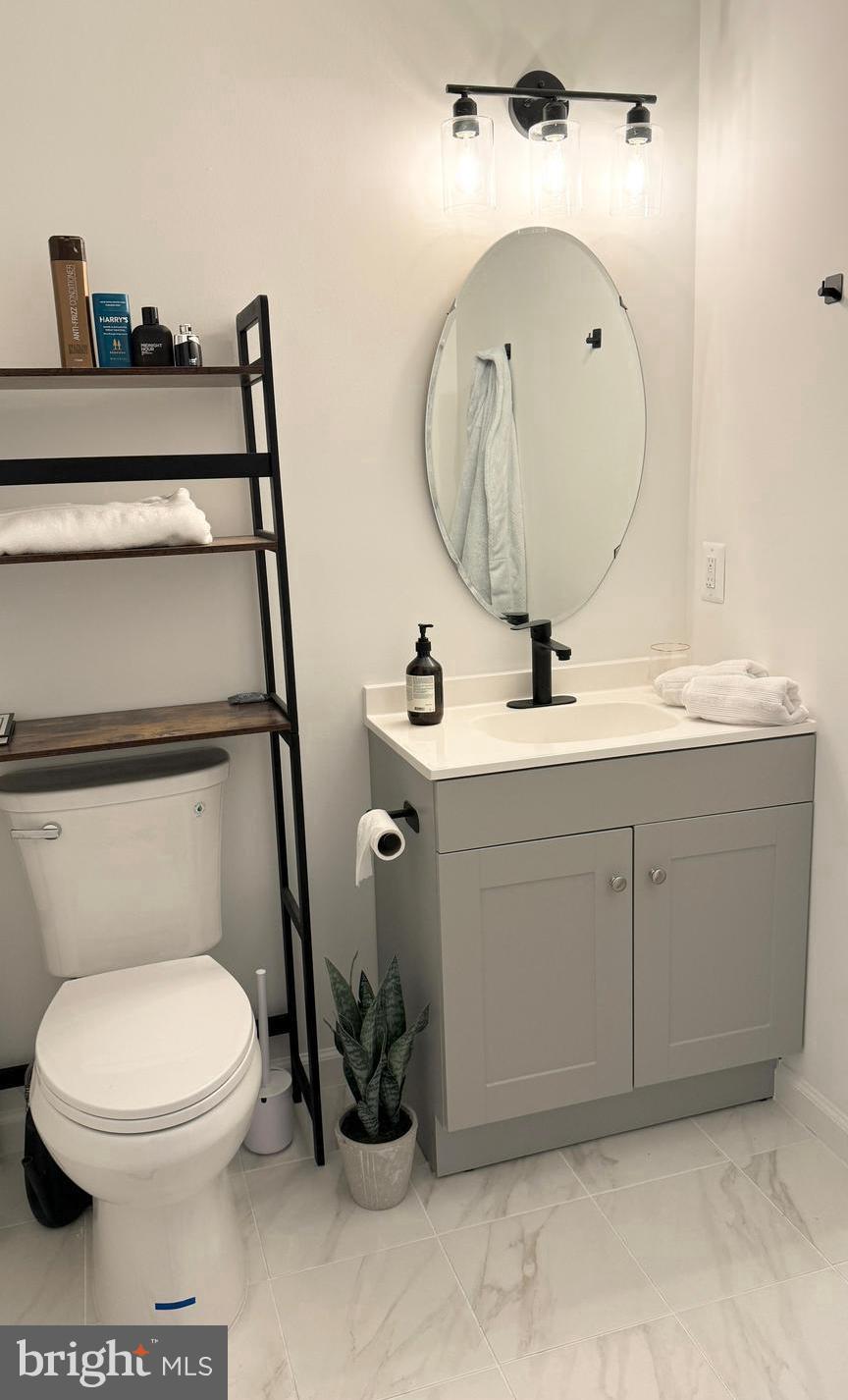 14660 Red House Road Gainesville, VA 20155 - Photo 17 of 20 a bathroom with a toilet a sink and mirror