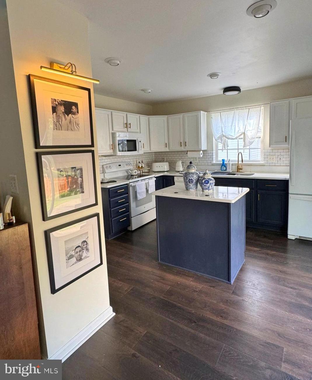14660 Red House Road Gainesville, VA 20155 - Photo 9 of 20 a kitchen with kitchen island wooden cabinets a stove a sink and a refrigerator