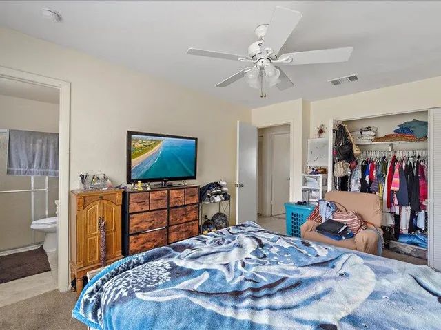 a bedroom with a bed and a flat screen tv