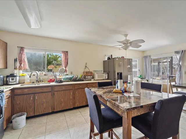 a kitchen with a dining table chairs and white cabinets