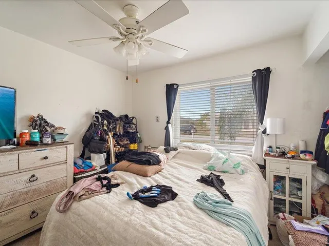 a bedroom with bed and a large window
