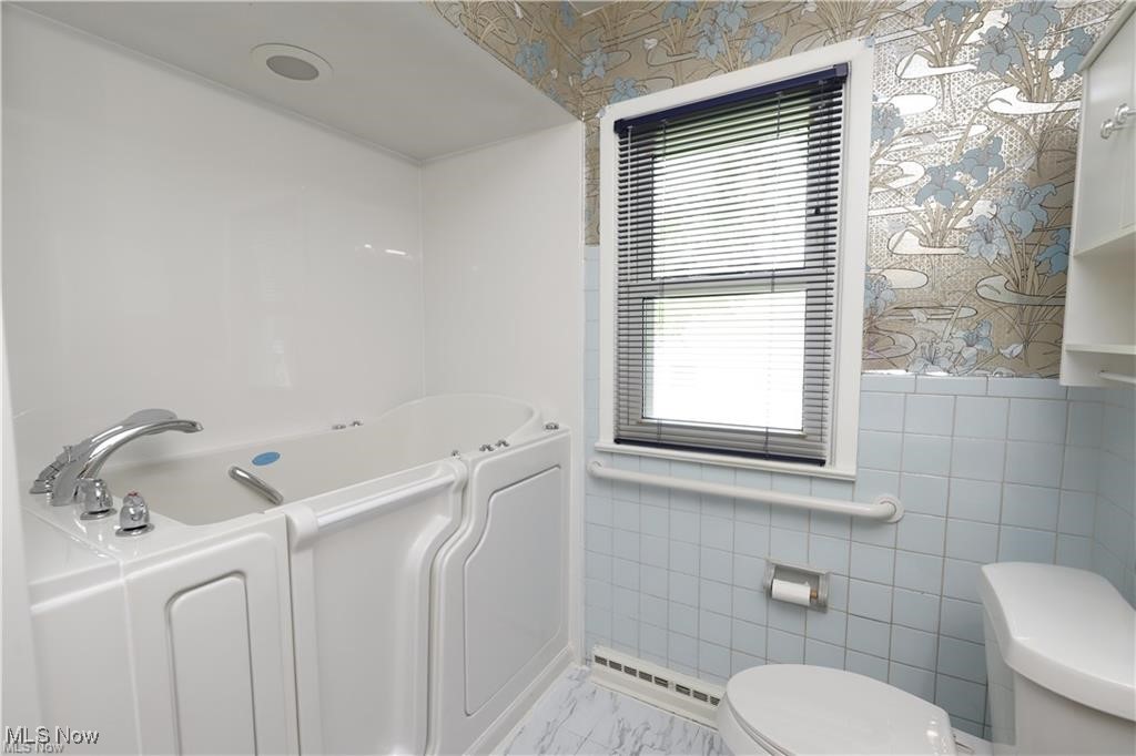 890 Wadsworth Road Medina, OH 44256 - Photo 10 of 22 Full bath featuring wallpapered walls, a bath, tile walls, and baseboard heating