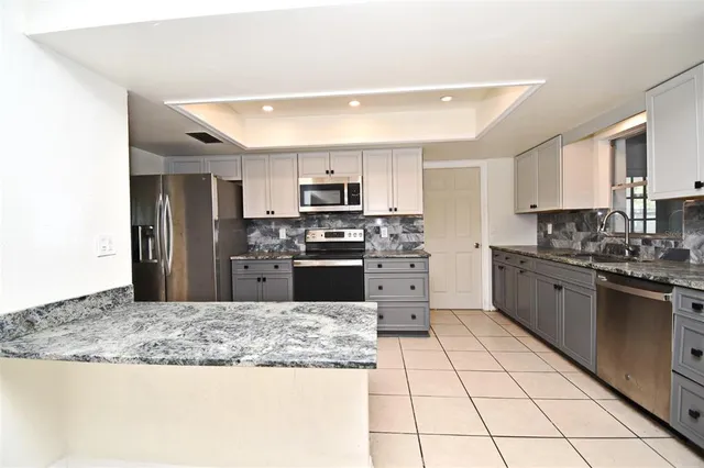 a kitchen with stainless steel appliances granite countertop a stove microwave and refrigerator