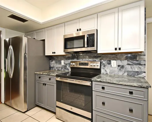a kitchen with granite countertop a sink and cabinets
