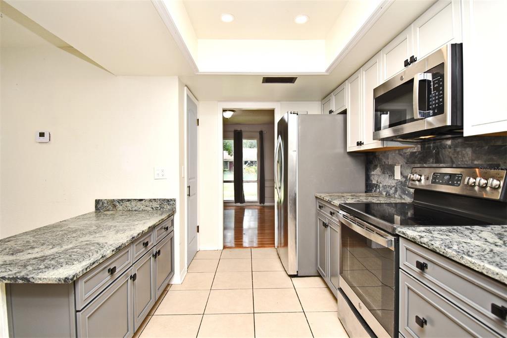 5133 Brenda Drive Orlando, FL 32812 - Photo 25 of 51 a kitchen with stainless steel appliances granite countertop a stove and a microwave