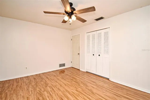 an empty room with a window and a ceiling fan