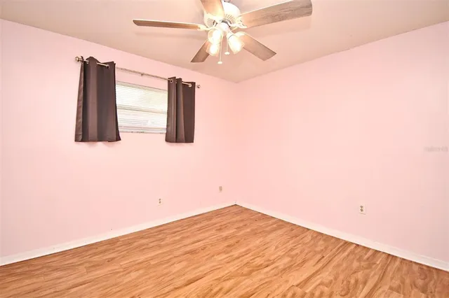 a view of a room with wooden floor and ceiling fan