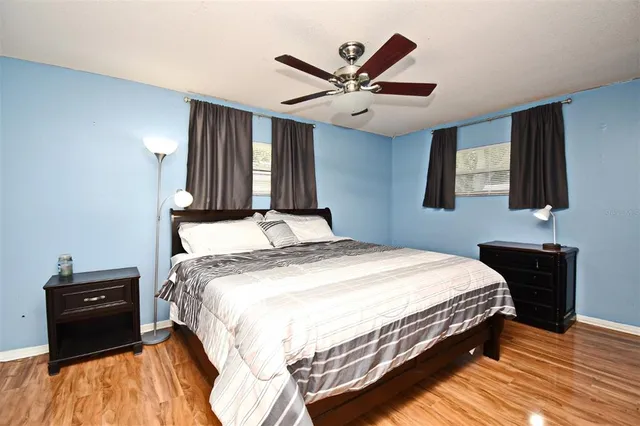 a bedroom with a large bed chandelier and a window