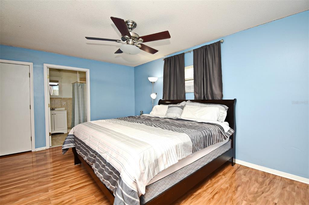 5133 Brenda Drive Orlando, FL 32812 - Photo 38 of 51 a bedroom with a large bed chandelier and a window