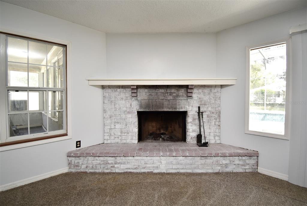 5133 Brenda Drive Orlando, FL 32812 - Photo 4 of 51 a living room with a fireplace and windows