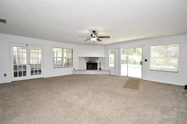 a view of an empty room with a fireplace and a window