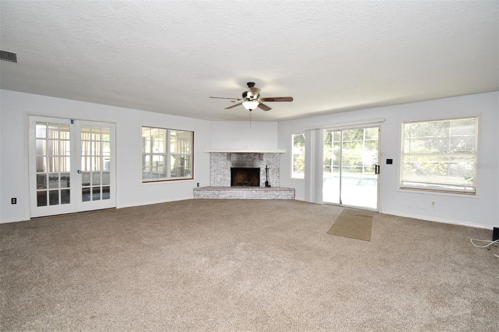 5133 Brenda Drive Orlando, FL 32812 - Photo 5 of 51 an empty room with windows and fireplace