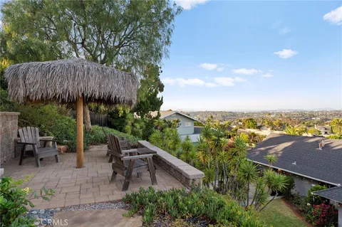 a view of a patio with furniture and a garden