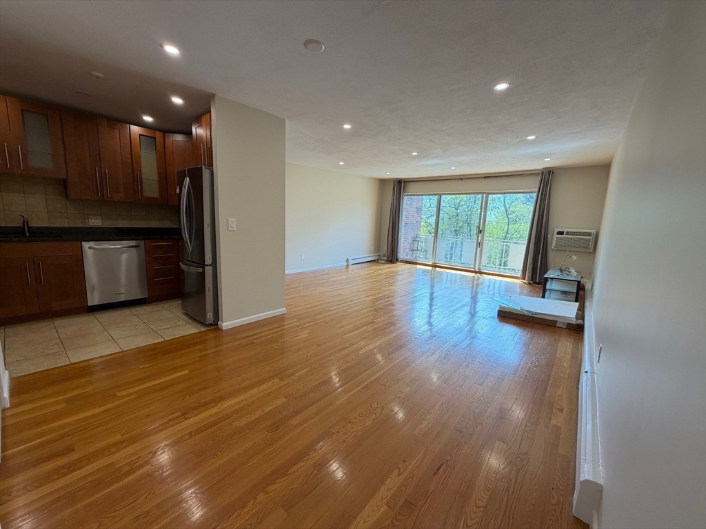 383 Langley Road, Unit 11 Newton, MA 02459 - Photo 13 of 15 a view of empty room with wooden floor and fireplace