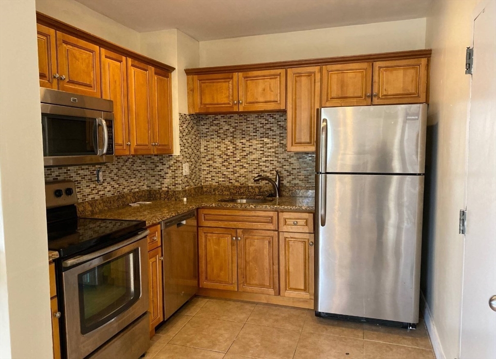 212 Maverick Street, Unit 3 Boston, MA 02128 - Photo 2 of 9 a kitchen with stainless steel appliances granite countertop a refrigerator a stove a sink and a microwave