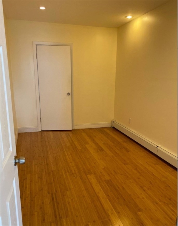 212 Maverick Street, Unit 3 Boston, MA 02128 - Photo 4 of 9 an empty room with wooden floor