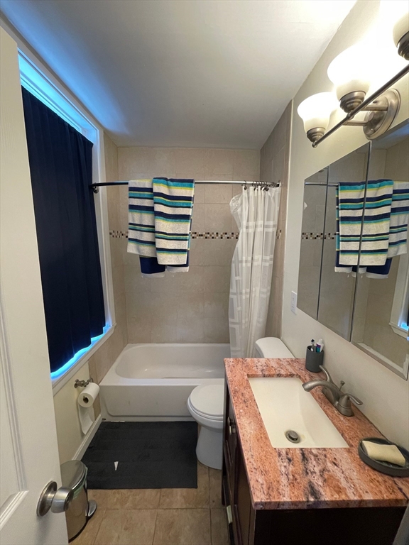 212 Maverick Street, Unit 3 Boston, MA 02128 - Photo 5 of 9 a bathroom with a granite countertop sink toilet and shower