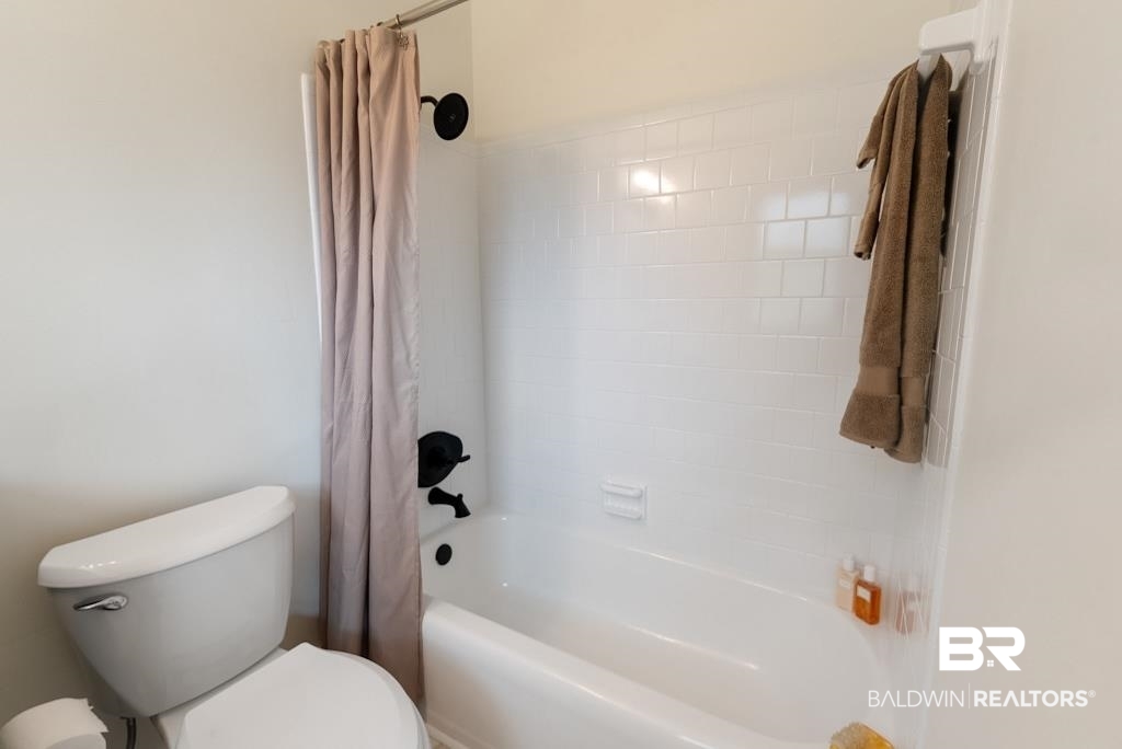554 Stuart Street Daphne, AL 36526 - Photo 9 of 49 Bathroom featuring toilet and shower / bathtub combination with curtain