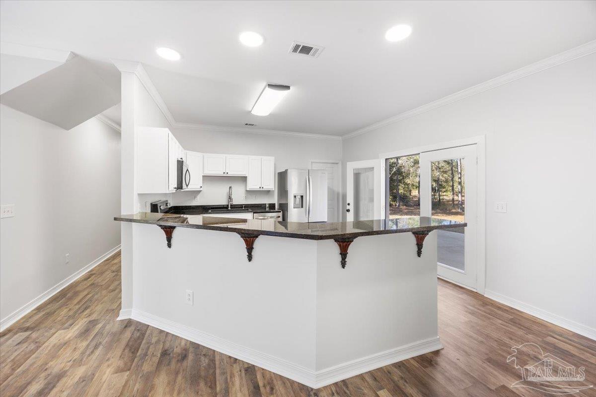 2099 Garcon Point Road Milton, FL 32583 - Photo 23 of 65 a view of kitchen with cabinets and wooden floor