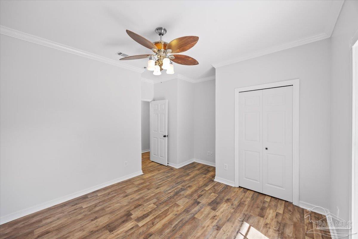 2099 Garcon Point Road Milton, FL 32583 - Photo 43 of 65 a view of a room with wooden floor and ceiling fan