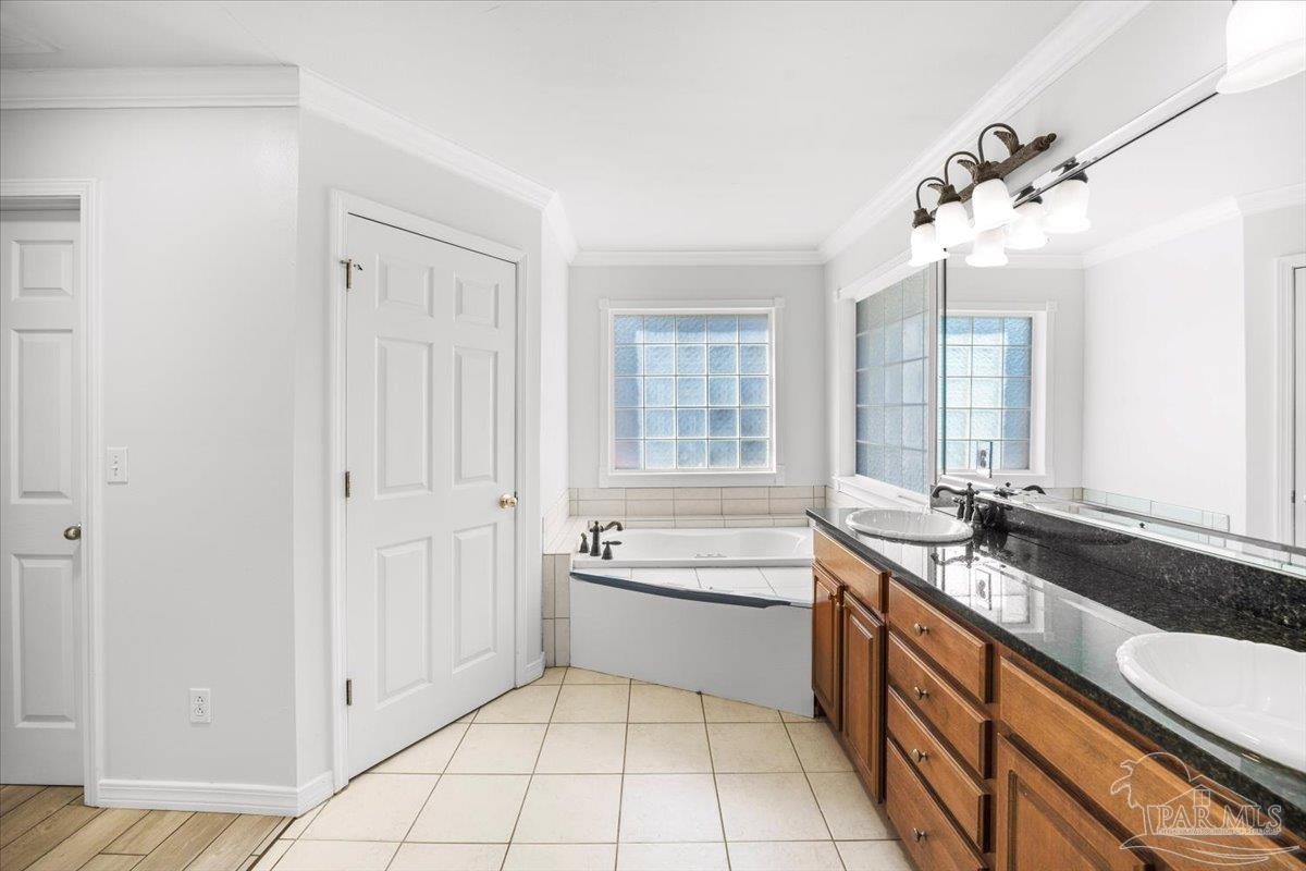 2099 Garcon Point Road Milton, FL 32583 - Photo 50 of 65 a spacious bathroom with a granite countertop sink a mirror and a bathtub